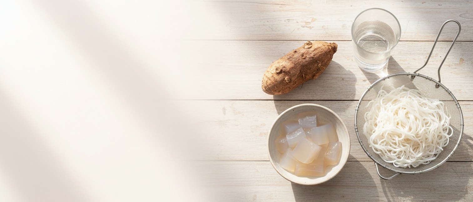 Konjac, gelée de konnyaku, nouilles shirataki et verre d’eau sur une table